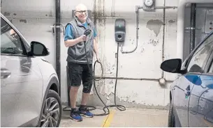  ?? NICOLE OSBORNE FOR THE TORONTO STAR ?? EV committee member Tom Reidel uses the charger in the garage of the Riverhouse condos.