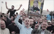  ?? KHALIL HAMRA THE ASSOCIATED PRESS ?? Yahya Sinwar, centre, Hamas leader in the Gaza Strip, chants slogans as he is surrounded by protesters Friday during his visit to the Gaza Strip's border with Israel.