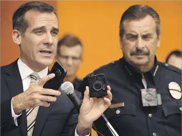  ?? Al Seib Los Angeles Times ?? LOS ANGELES Mayor Eric Garcetti, left, shows the new LAPD body camera with LAPD Chief Charlie Beck. LAPD policy does not allow police videos to be released, a decision that has stirred up heated debate.