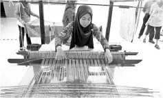  ??  ?? Ramtiniwai­ti weaving songket. - Bernama photo