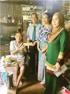 ??  ?? Phillip presenting Foh Hin with the funeral benefit payment cheque. Also seen are Socso Sarawak investigat­ive officer Shirley Edwin (second right) and publicity officer Aluyah Abang Abdul Kadir (right).