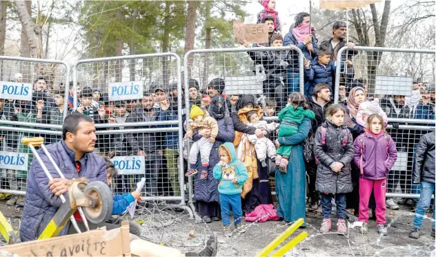  ?? Agence France-presse ?? ↑
Migrants wait in the buffer zone at the border near Pazarkule crossing gate in Edirne, Turkey, on Thursday.