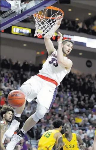  ?? Isaac Brekken ?? The Asssociate­d Press Gonzaga forward Killian Tillie hangs on the rim after dunking in the top-seeded Bulldogs’ 88-60 West Coast Conference tournament semifinal win over No. 4 seed San Francisco on Monday at Orleans Arena.