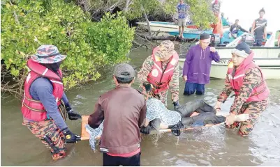  ??  ?? ANGGOTA operasi mengusung mayat mangsa sebelum diserahkan kepada