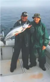  ?? PROVIDED PHOTO ?? Tom Zurek caught this 17-pound coho (Capt. Bob Poteshman is holding the fish), an early promise of some really big coho in southern Lake Michigan, on June 6.