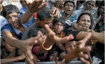  ?? GETTY IMAGES ?? Desperate Rohingya refugees reach for handouts of clothing and food at an aid centre in Tankhali, Bangladesh.