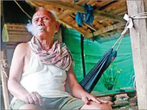  ?? VIREAK MAI ?? Meas Muth, former Khmer Rouge navy chief and war crimes suspect, smokes a cigarette at his house in Battambang in 2015.