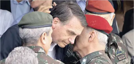  ??  ?? ► Efectivos militares conversan con Jair Bolsonaro durante un acto en Río de Janeiro, en noviembre.