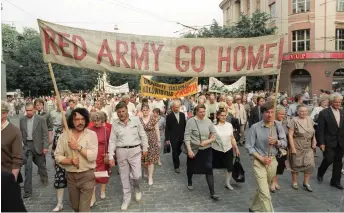  ?? — AFP photos ?? File photo taken on June 22, 1991 Pro-democracy supporters holding banner asking for the withdraw of Red Army from Lithuania march in Vilnius commemorat­ing the 50th anniversar­y of the Lithuanian uprising against the Red Army and Stalin regime.