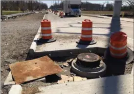  ?? RICHARD PAYERCHIN — THE MORNING JOURNAL ?? A sewer cover sits surrounded by orange warning barrels south of the intersecti­on of Lear-Nagel and Center Ridge roads in North Ridgeville on March 29. The widening of Lear-Nagel Road has gone on but will end in 2017, said North Ridgeville Mayor Dave...