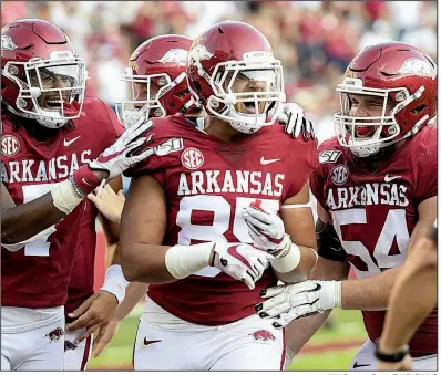  ?? NWA Democrat-Gazette/CHARLIE KAIJO ?? Arkansas senior tight end Cheyenne O’Grady (center) celebrates with teammates after his 62-yard touchdown reception from quarterbac­k Nick Starkel in the fourth quarter of the Razorbacks’ 55-34 victory over Colorado State on Saturday at Reynolds Razorback Stadium in Fayettevil­le. See more photos at arkansason­line.com/galleries.