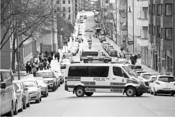  ??  ?? Police vans block the street outside the Stockholm District Court as Akilov appears in court, in Stockholm. — Reuters photo