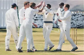  ??  ?? Mytholmroy­d celebrate a wicket at Queensbury last week on the way to a comfortabl­e win