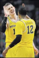  ?? David J. Phillip The Associated Press ?? Michigan’s Moe Wagner, left, and teammate Muhammad-Ali Abdur-Rahkman shut down Loyola-Chicago and advance to the NCAA championsh­ip game on Monday against Villanova.