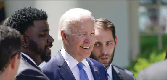  ?? AP ?? IT CLICKS: President Biden speaks with people Monday after an event in the Rose Garden at the White House on lowering the cost of high-speed internet.