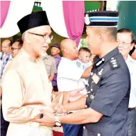  ??  ?? TAWFIQ bersalaman dengan OCPD Tawau.