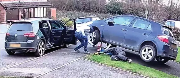  ??  ?? > Thieves caught on camera stealing a catalytic converter from a driveway in Hurley, North Warwickshi­re, at 5.30pm on Sunday as the owner ate his dinner