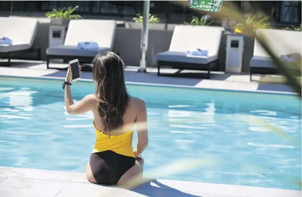  ??  ?? Poolside selfies, popularize­d by “swimfluenc­ers” like Ashley Graham and Nicki Minaj, seem to be guiding women toward one-piece suits this season.