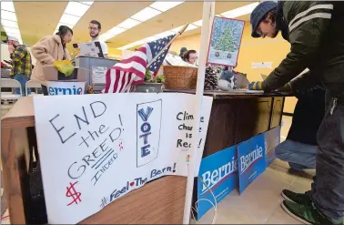  ?? TIM COOK/THE DAY ?? Volunteers from Connecticu­t check in Saturday at the campaign offices of Sen. Bernie Sanders in Manchester, N.H., as they prepare to canvass the local neighborho­ods. The volunteers were trying to persuade voters to back Sanders in the New Hampshire primary on Feb. 11.