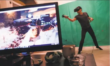  ?? Nick Otto / Special to The Chronicle ?? Daniel Kravtsov takes a break from working late into the night to play a virtual reality game in the living room of his home in Hayes Valley. He often works until 3 a.m. so he can call his developers in Russia.