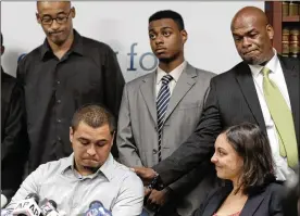  ?? RICHARD DREW / AP ?? A plaintiff in a 2013 stop-and-frisk case David Ourlicht (seated left) is comforted by Merault Almonar (standing right) father of plaintiff Devin Almonar (center). A U.S. district judge ruled that the New York Police Department deliberate­ly violated the civil rights of tens of thousands with its contentiou­s stop-and-frisk policy.