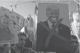  ??  ?? Des manifestan­ts palestinie­ns brandissan­t des portraits de l’ancien leader palestinie­n Yasser Arafat et du président américain Donald Trump lors d’un rassemblem­ent dans la ville de Naplouse, en Cisjordani­e occupée, le 18 juillet 2018.