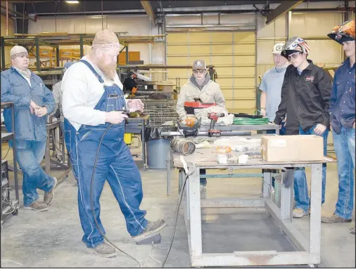  ?? Rachel Dickerson/McDonald County Press ?? Cody Epperly (left of center) gives a presentati­on on TIG welding at McDonald County High School as students gather around on April 3.