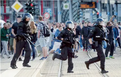  ?? AFP ?? Police officers run during protests in the eastern german city of Chemnitz amid tensions over the killing of a man in what police described as a dispute between several people of various nationalit­ies. —