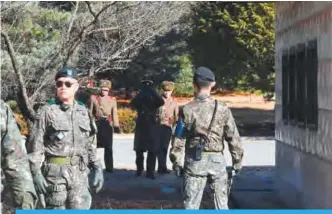  ?? —AFP ?? PANMUNJOM: North Korean soldiers stare at South Korean soldiers at the truce village of Panmunjom in the Demilitari­zed zone (DMZ) during a visit by Seoul’s defense chief Song Young-Moo following a dramatic defection by a North Korean soldier through...