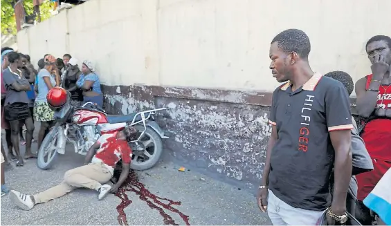  ?? AP ?? Violencia sin límites. El cuerpo de un hombre en medio de un charco de sangre tras ser atacado en Delmas, vecindario de la capital de Haití.