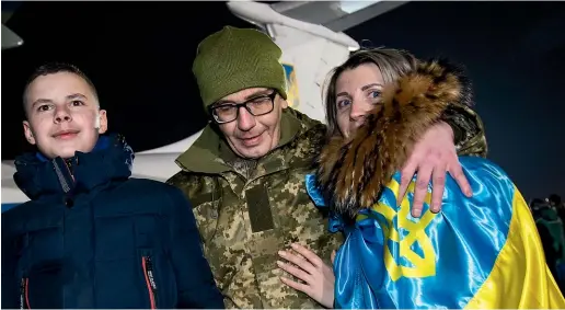  ?? AP ?? Relatives and a Ukrainian prisoner of war released after a prisoner exchange walk from a plane upon his arrival at Boryspil airport, outside Kiev, Ukraine.