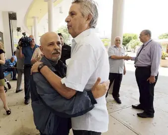 ??  ?? EL ABOGADO Nicolás Medina, padre de la asesora Ataveyra Medina Hernández (abajo), abraza a su amigo, el periodista Manolo Coss, en el Centro Médico de Río Piedras.