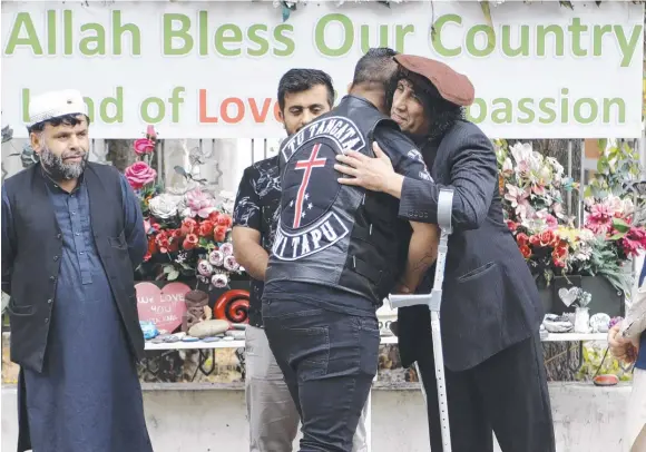  ??  ?? Mosque massacre survivor Taj Mohammed Kamran greets a member of the Tu Tangata motorcycle club at a memorial to the tragedy. Picture: AP
