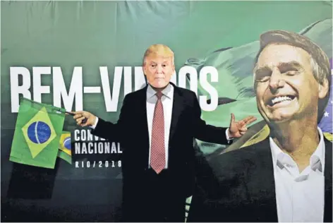  ??  ?? ► Un partidario de Bolsonaro con una máscara de Trump durante una convención en Río de Janeiro.