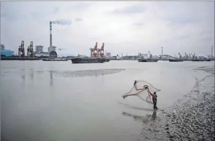  ?? Photos: Johannes Eisele/afp & AFP ?? Complex transistio­n: A man fishes across from the Wujing coal power station in Shanghai, China and electrical workers in a boat check solar panels at a photovolta­ic power station built in a fishpond in Haian, China. Mzukisi Qobo writes that China calibrates its pragmatic use of coal with increasing investment­s in renewable energy rather than basing its future decisions purely on idealism.