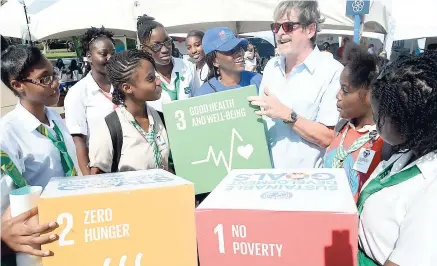  ??  ?? Mark Connolly, United Nations resident coordinato­r in Jamaica, chats with students at the recent World UN Day Expo in Emancipati­on Park, New Kingston.