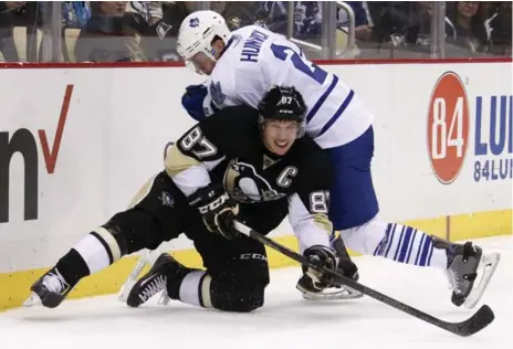  ?? GENE J. PUSKAR/THE ASSOCIATED PRESS ?? Maple Leafs defenceman Matt Hunwick takes out Penguins captain Sidney Crosby during second-period action Saturday night in Pittsburgh.