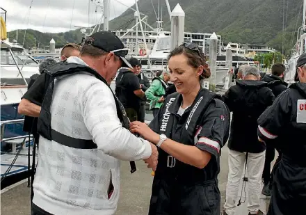  ?? GEOFF VAUSE ?? Coastguard Marlboroug­h’s Janette St John helps a trainee into his life jacket at the popular boating safety workshop held at Picton.