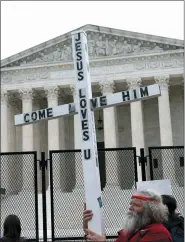  ?? ASSOCIATED PRESS FILE PHOTO ?? A demonstrat­or holding a cross protests outside of the U.S. Supreme Court on Thursday. America’s faithful are bracing, some with cautionary joy and others with looming dread, for the Supreme Court to potentiall­y overturn the landmark 1973 Roe v. Wade decision and end the nationwide right to legal abortion.