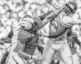  ?? John Moore / Associated Press ?? Romeo Booker, right, and his UH teammates weren’t happy about taking it on the chin from Eli Howard and Texas Tech on Saturday.