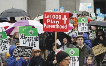  ??  ?? In this Jan. 22 file photo, people taking part in an anti-abortion march hold signs as they stand on the steps of the Legislativ­e building at the Capitol in Olympia, Wash. AP Photo/ted S. WArren