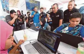 ?? BERNAMA PIC ?? Deputy Defence Minister Datuk Seri Mohd Johari Baharom (third from right) watching National Service trainees trying their hands at ‘Camp Warriors’ in Jitra yesterday.