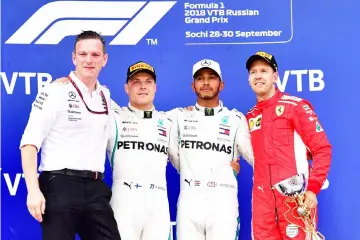  ?? — AFP photo ?? Winner Mercedes’ British driver Lewis Hamilton (seond right), second placed Mercedes’ Finnish driver Valtteri Bottas (second left) and third placed Ferrari’s German driver Sebastian Vettel (right) celebrate during the podium ceremony for the Formula One Russian Grand Prix at the Sochi Autodrom circuit in Sochi in this Sept 30 file photo.