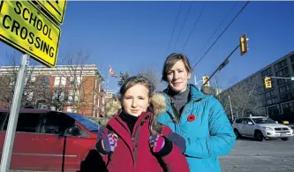  ?? CLIFFORD SKARSTEDT/EXAMINER FILES ?? Melissa Petrauskas and her daughter Abby, 10, a student at King George Public School, are seen Nov. 10 at the corner of Hunter Street East and Armour Road in East City. They are concerned about the corner’s safety after Abby was taken to Peterborou­gh...
