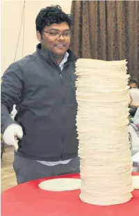  ??  ?? ●●Joy Ehsan stands in front of his recordbrea­king stack of tortillas