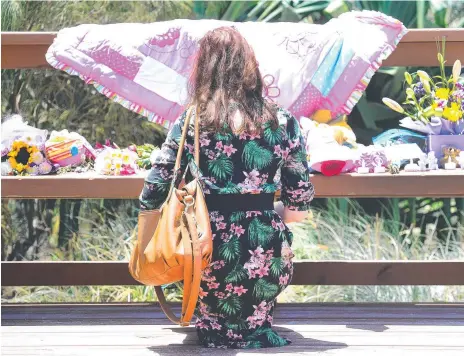  ?? Picture: AAP ?? A woman stops to pay her respects at Surfers Paradise following the discovery of the body of a nine-month-old girl.