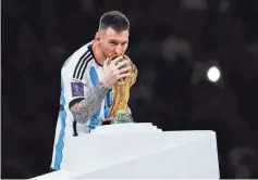  ?? YUKIHITO TAGUCHI/ USA TODAY SPORTS ?? Argentina forward Lionel Messi kisses the World Cup trophy after winning the 2022 final against France in Qatar.