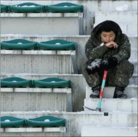  ?? CHARLIE RIEDEL — THE ASSOCIATED PRESS ?? A soldier takes a break from shoveling snow and ice from the seating area at the Alpensia Ski Jumping Center ahead of the 2018 Winter Olympics in Pyeongchan­g, South Korea Wednesday.