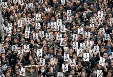  ?? PHOTO: GETTY IMAGES ?? Crowds of people hold up photograph­s of the late Thai King Bhumibol Adulyadej as they wait in line to attend his funeral in Bangkok.