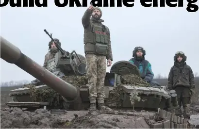  ?? YEVHEN TITOV/AGENCE FRANCE-PRESSE ?? UKRAINIAN tankers stand atop their tank in a field near an undisclose­d frontline position in eastern Ukraine.